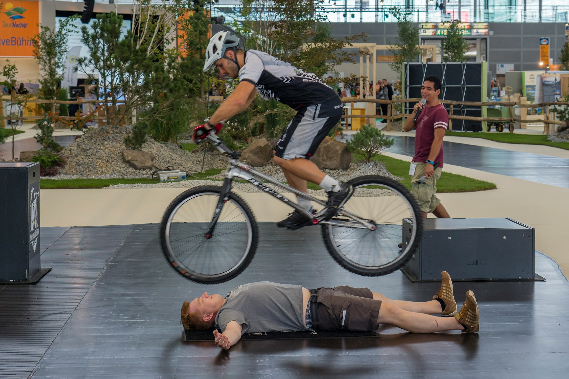 Two men performing a dangerous stunt on a bicycle